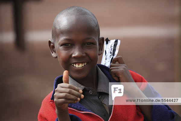 Boy  smiling  holding up his thumb  portrait  Tanzania  Africa