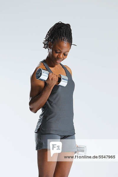 African Woman Exercising With Dumbbells