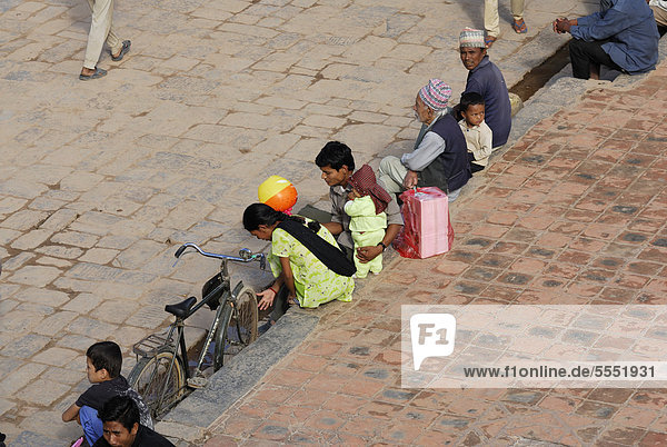 Kind  Frauen und Männer auf dem Taumadhi-Platz  Bhaktapur  Kathmandu-Tal  Nepal  Asien