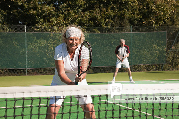 Senior and mature adults playing tennis