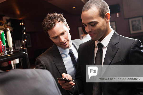 Geschäftsleute suchen Smartphone in der Bar