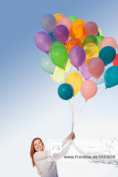 Junge Frau im Freien mit Luftballons