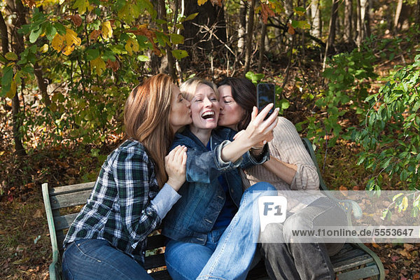 Mature female friends photographing themselves