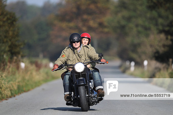 Paar fährt Motorrad auf einer Landstraße