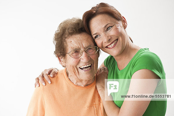 Lächelnde reife und alte Frau umarmen sich
