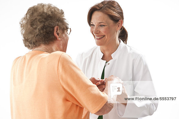 Old woman and doctor smiling at each other