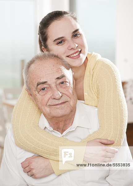 Young woman hugging senior man  portrait