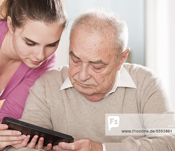 Young woman and senior man with tablet pc