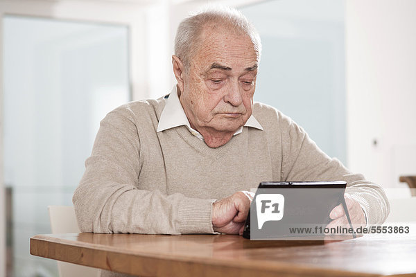 Senior man using netbook at table