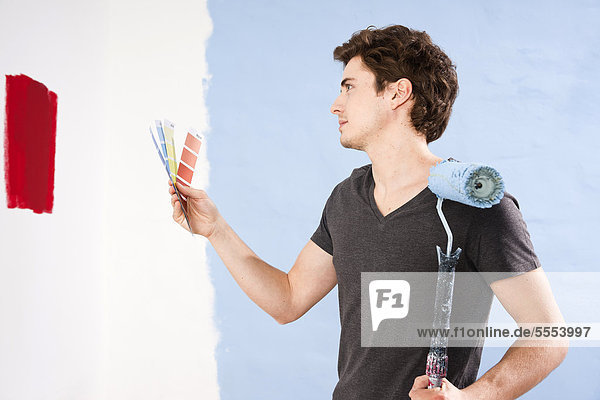 Young man deciding between different wall colors