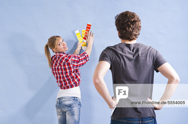 Young couple looking at different wall colors
