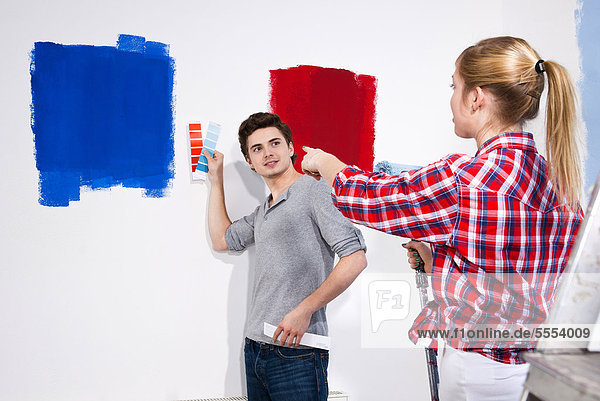 Junges Paar streicht eine Wand
