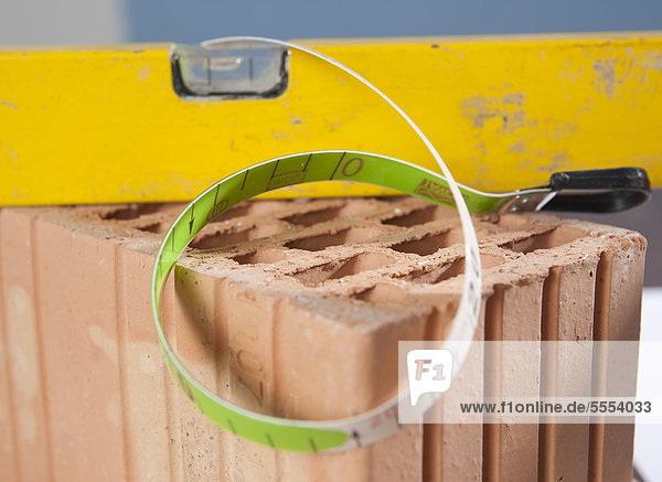 Measuring tape  mechanic's level and claybrick