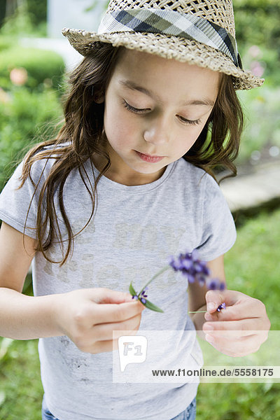 Mädchen untersucht Blume im Freien