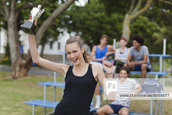 Woman holding trophy in park