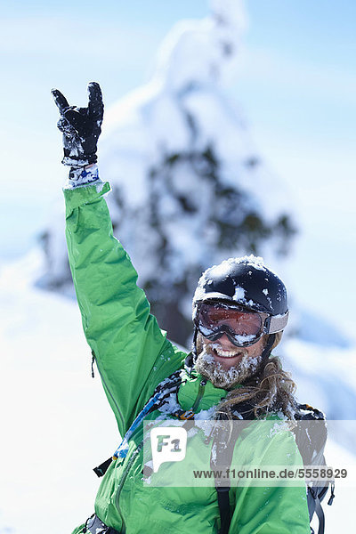 Skier making hand gesture in snow