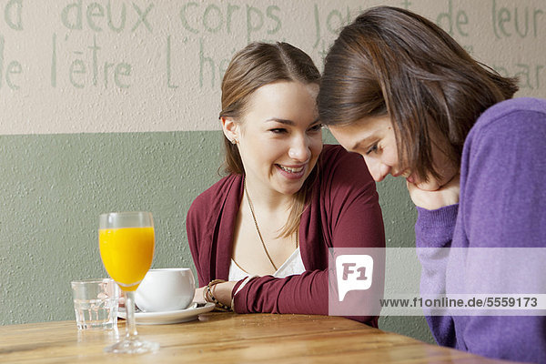 Lächelnde Frauen reden im Cafe