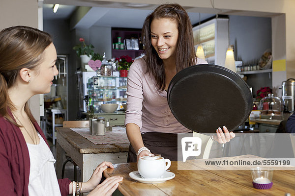 Waitress serving woman in cafe
