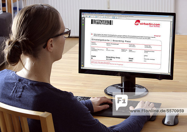 Frau am Computer surft im Internet  bucht einen Flug  AirBerlin-Portal  Einsteigekarte  Boarding Pass für einen Flug zum Selbstausdrucken