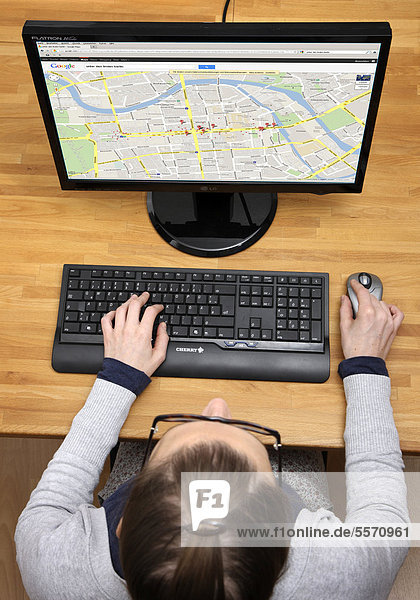 Frau am Computer surft im Internet  Web-Recherche  Google Maps