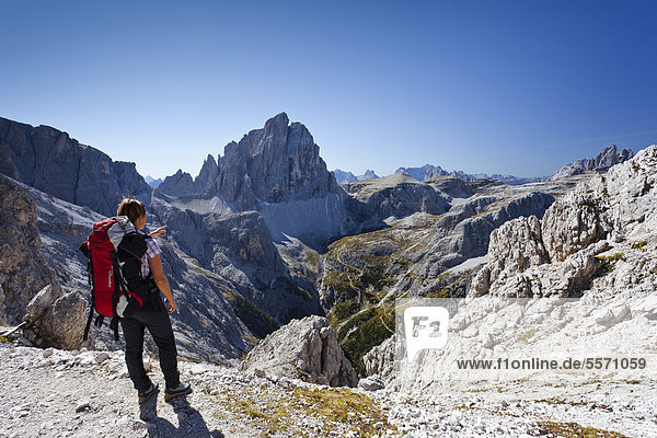 Wanderer auf der Elferscharte  beim Aufstieg zum Alpinisteig  hinten der Zwölferkofel  die Drei Zinnen  Sexten  Hochpustertal  Dolomiten  Südtirol  Italien  Europa