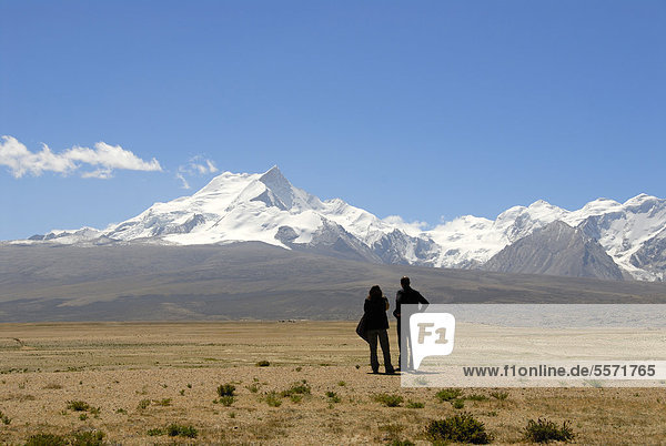 Two people in silhouette  wide landscape  near Lake Pelku Tso  high plateau  looking towards Mount Shishapangma  8013 m  Himalayas  Central Tibet  U-Tsang  Tibet Autonomous Region  People's Republic of China  Asia