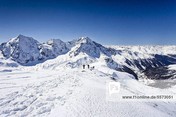 Skitourengeher beim Abstieg der hinteren Schöntaufspitze  Sulden  hinten die Königsspitze  der Zebru und Ortler sowie das Suldental  Südtirol  Italien  Europa