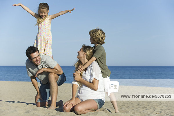Familie spielt zusammen am Strand