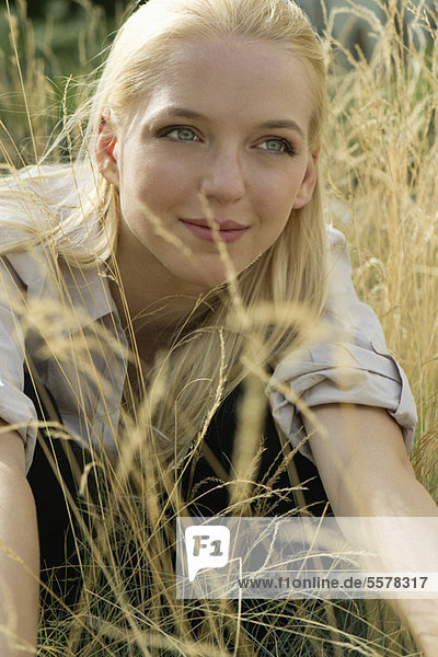 Young woman relaxing in tall grass  portrait