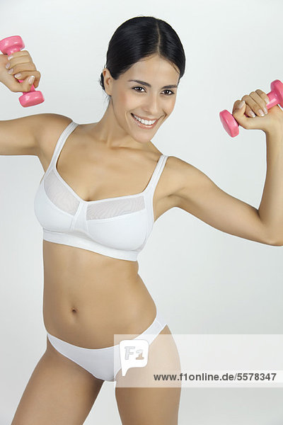 Woman in underwear lifting dumbbells