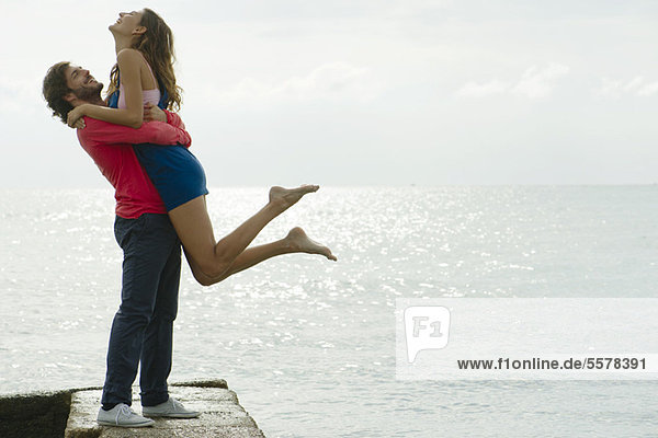 Young man lifting girlfriend up  portrait