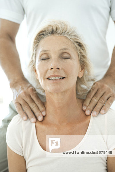 Mature woman having her shoulders massaged