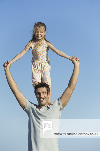 Girl standing on father's shoulders