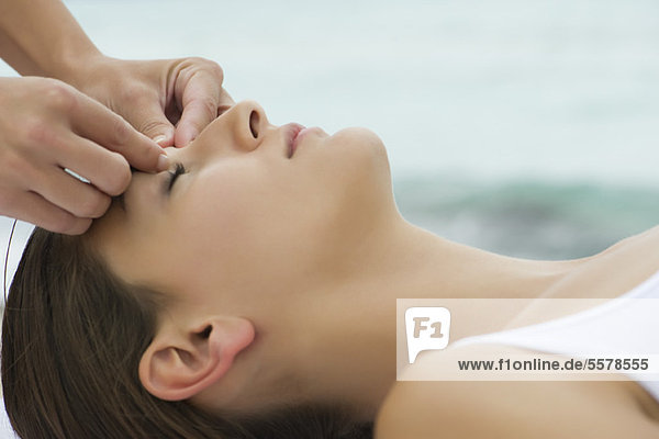 Young woman receiving face massage  side view