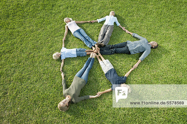 People on grass forming shape of shield