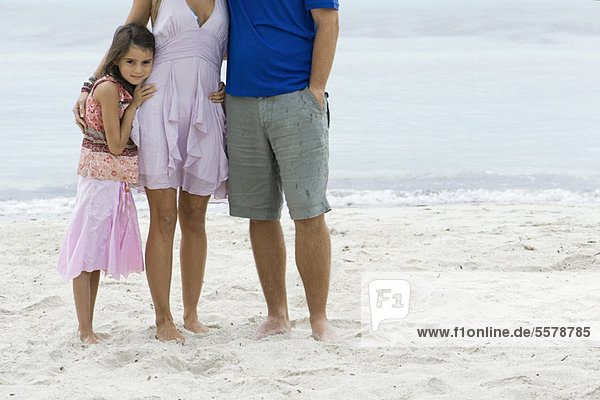 Mädchen und Eltern am Strand stehend  beschnitten