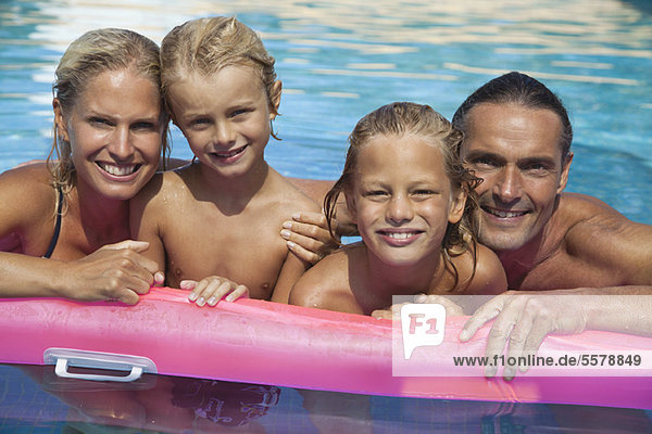 Family relaxing together in pool  portrait