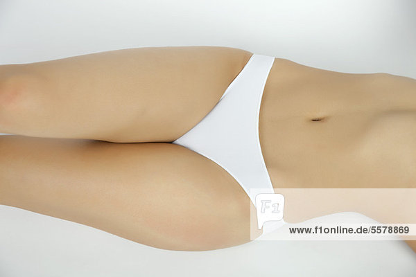 Woman lying on back in underwear  mid section