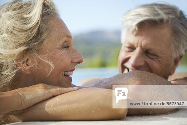 Mature couple relaxing together in pool