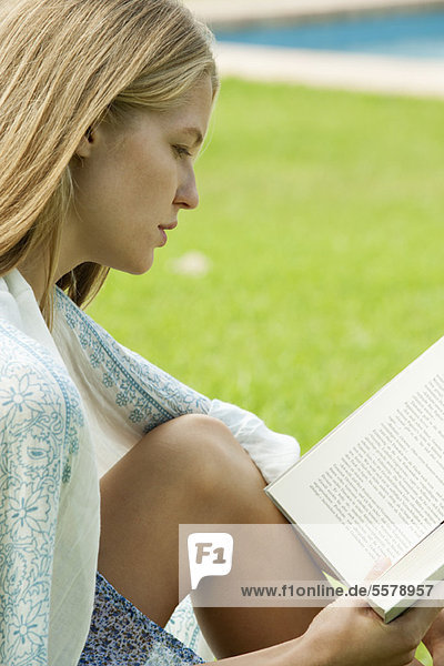 Junge Frau beim Lesen im Freien