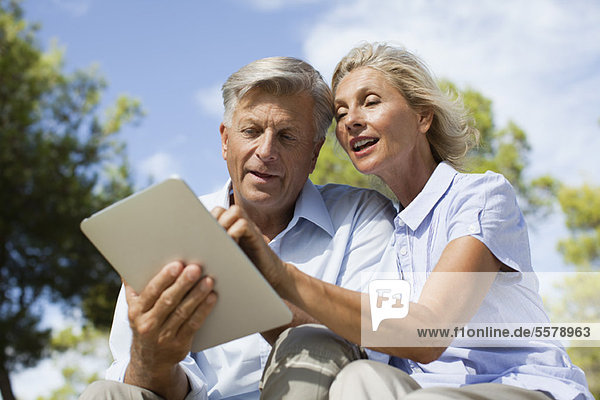 Couple using digital tablet outdoors