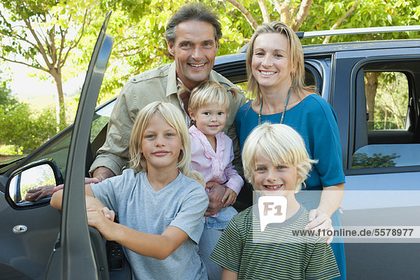 Family posing beside car  portrait