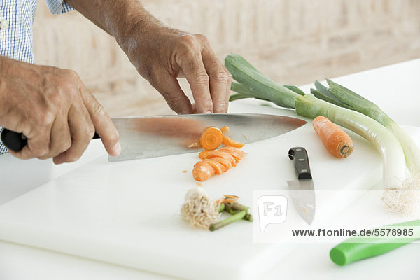 Man slicing fresh vegetables  cropped