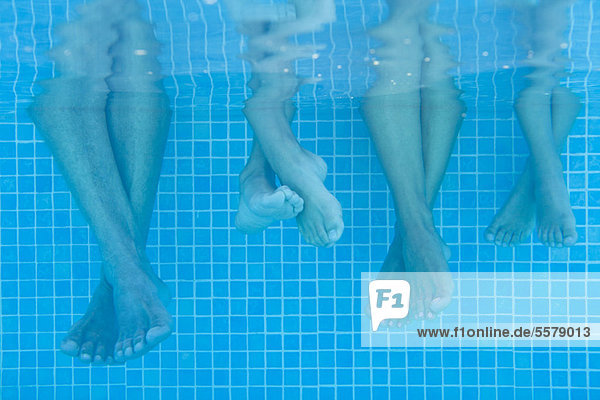 Family soaking feet in pool  underwater view