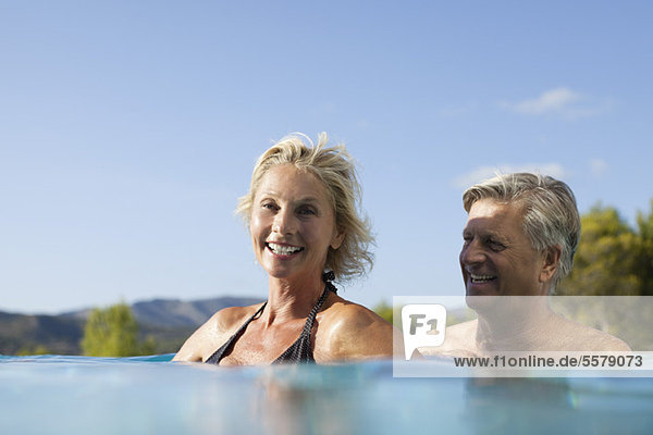Mature couple relaxing together in pool