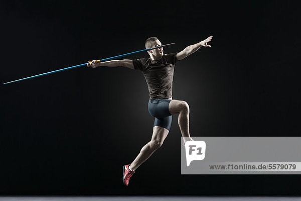 Male athlete leaping with javelin