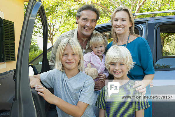 Family posing beside car  portrait