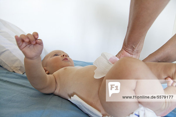 Baby having diaper changed  cropped