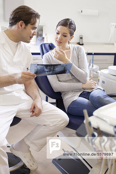 Zahnarzt mit Patientin in Behandlungsraum