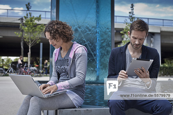 Man and woman with ipad and laptop